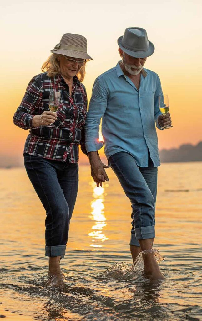 couple walking in the water while holding hands retirement future